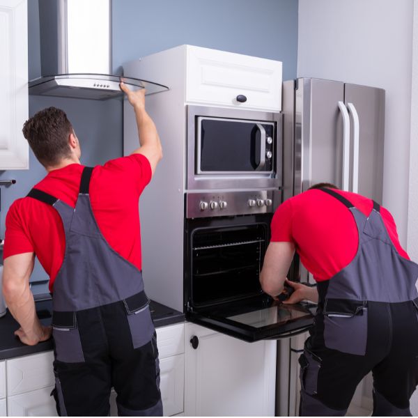 فني يقوم بإصلاح فرن غاز