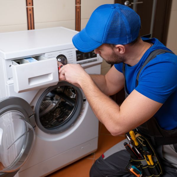فني يقوم بصيانة غسالة ملابس